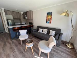 a living room with a couch and chairs and a kitchen at laguna verde apart in Los Ángeles
