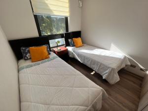 a bedroom with two beds and a window at laguna verde apart in Los Ángeles