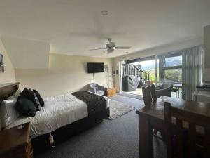 a bedroom with a bed and a dining room with a table at Coromandel Seaview Motel in Coromandel Town
