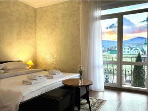 a hotel room with a bed and a large window at Котедж в ГОРАХ in Solochyn