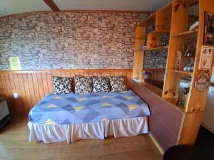 a bedroom with a bed with a stone wall at Cabaña León in Puerto Natales