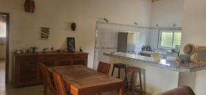 a kitchen with a wooden table and a counter top at Belle maison dans résidence avec piscine in Cap Skirring +6 photos