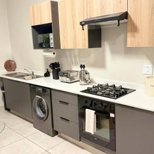a kitchen with a stove and a washing machine at Kurhula nest in Midrand
