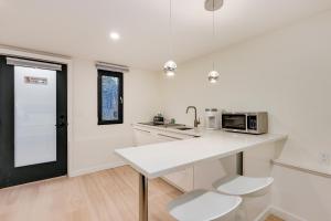 a white kitchen with a counter and a microwave at Classic King Size Guest Suite with AC in Burnaby