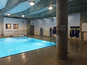 a large swimming pool in a gym with a pillar at Adelaide Stays and Suites - Walk to Subway - Easy Access Downtown Toronto in Vaughan