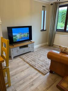 a living room with a flat screen tv on a table at Whitepark Lodge in Lisnaskea