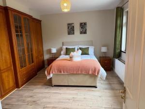 a bedroom with a bed with a orange comforter at Whitepark Lodge in Lisnaskea