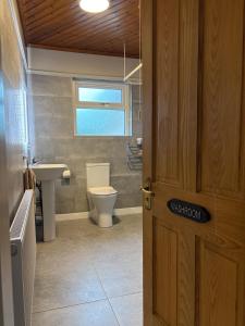 a bathroom with a toilet and a sink and a door at Whitepark Lodge in Lisnaskea +20 photos