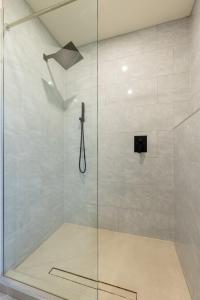 a shower with a glass door in a bathroom at Modern King-Size Guest Suite with AC in Burnaby