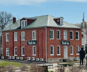 a person standing in front of a large brick building at Nestle Inn in Hermann