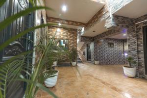 a lobby with potted plants and a stone wall at We care 4u lodge in Kasoa