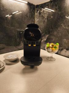 a coffee maker sitting on a table with a bowl of fruit at Ferienwohnung Burgperle Burghausen nahe weltlängster Burg zentral 24h Check in in Burghausen +17 photos