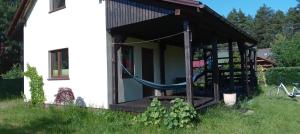a porch of a house with a hammock at Dom Leśny in Wachów