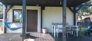 a porch with a hammock and a table and chairs at Dom Leśny in Wachów +7 photos