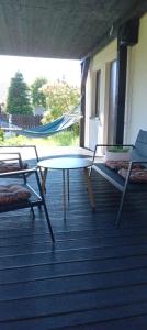 a hammock and a table and chairs on a porch at Dom Leśny in Wachów