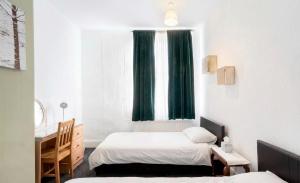 a bedroom with two beds and a desk and a window at Rotherham Kimberworth in Kimberworth