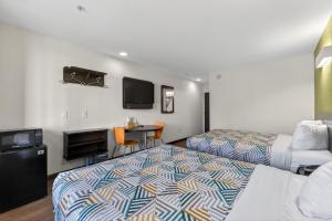 a hotel room with two beds and a flat screen tv at Motel 6-Gastonia Charlotte I-85 in Gastonia