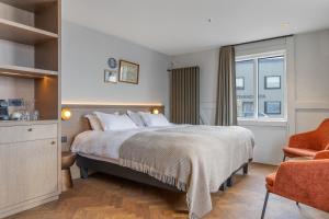 a hotel room with a bed and a chair at Bryggjan Boutique Hotel in Akureyri