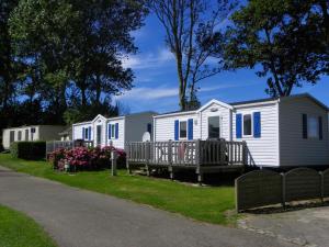 a row of mobile homes on the side of a road at Camping du Mesnil - Gaia Vacances in Saint-Aubin-sur-Mer