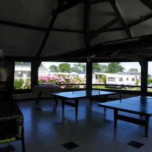 a group of tables in a pavilion with flowers at Camping du Mesnil - Gaia Vacances in Saint-Aubin-sur-Mer