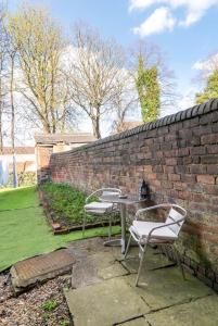 two chairs and a table next to a brick wall at Rotherham Kimberworth in Kimberworth