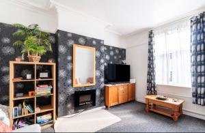 a living room with a tv and a mirror at Rotherham Kimberworth in Kimberworth
