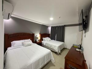 a hotel room with two beds and a flat screen tv at Hotel Rubinos in San Salvador +198 photos