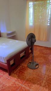 a bedroom with a bed with a fan on the floor at Value guests in Magaeline