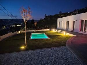 a backyard with a swimming pool at night at Douro Garden in Resende