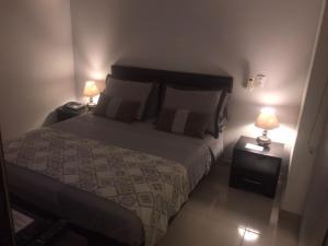 a bedroom with a bed and two lamps on tables at Confortable y Tranquilo Aparta Suite en el Corazón de Bucaramanga, Exterior con hermosa vista sobre la ciudad in Bucaramanga
