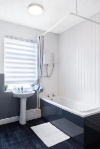 a bathroom with a white tub and a sink at Rotherham Kimberworth in Kimberworth +17 photos