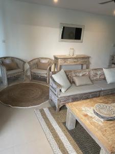 a living room with a couch and chairs and a table at Villa Penyon in Nusa Lembongan