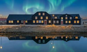 a large black building with a reflection in the water at Bryggjan Boutique Hotel in Akureyri