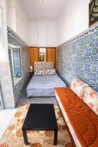 a room with a couch and a bed in it at Cosy Riad Cœur Medina in Rabat