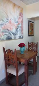 a dining room table with a vase of flowers on it at Suite em Lumiar in Lumiar