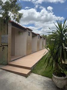 a row of buildings with a porch and a palm tree at Hotel pousada Xique Xique in Piranhas