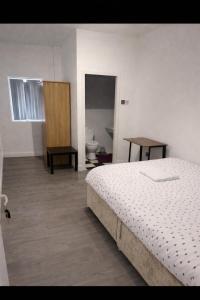 a bedroom with a bed and a bathroom with a toilet at The Coach House in Bradford