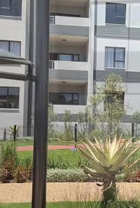 a apartment building with a plant in front of a pole at Kurhula nest in Midrand