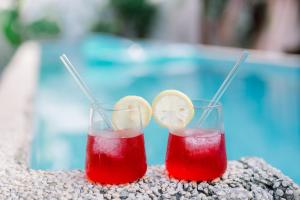 two cocktails sitting on a table next to a pool at Alaya Panglao in Panglao Island