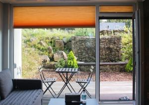 a living room with a couch and a sliding glass door at Jeju Teracehill Pension in Jeju