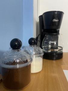 two containers of food sitting on a counter with a coffee maker at Suite De Descanso En Urbanización Residencial FRENTE AL AEROPUERTO in Maiquetia