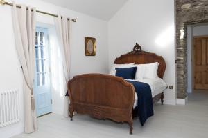 a bedroom with a bed with blue and white pillows at Lil's Cottage, Grangecon in Grange Con