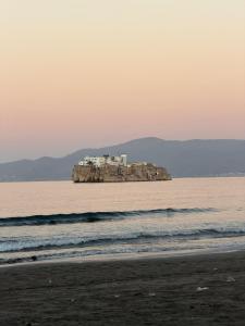 a island in the ocean with a house on it at Apparemment à Radisson Blu Apartment Alhoceima Beach Access in Al Hoceïma