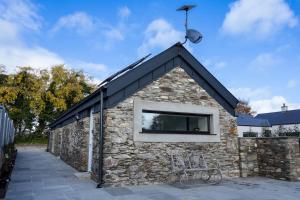 a stone building with a window on top of it at Lil's Cottage, Grangecon in Grange Con