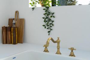 a bathroom sink with a brass faucet and a vase at Lil's Cottage, Grangecon in Grange Con +23 photos