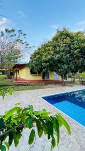 a villa with a swimming pool in front of a house at Cabaña Villa Hellen in Santa Marta