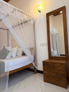 a bedroom with a canopy bed and a mirror at villa Senoa in Ahangama