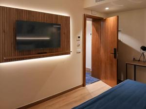 a bedroom with a large television on the wall at Hotel Infante Santo - Lisboa in Lisbon