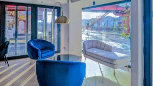 a room with two blue chairs and a window at Hotel Infante Santo - Lisboa in Lisbon