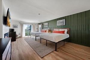 two beds in a room with green walls at Hotel Dega in Bodega Bay